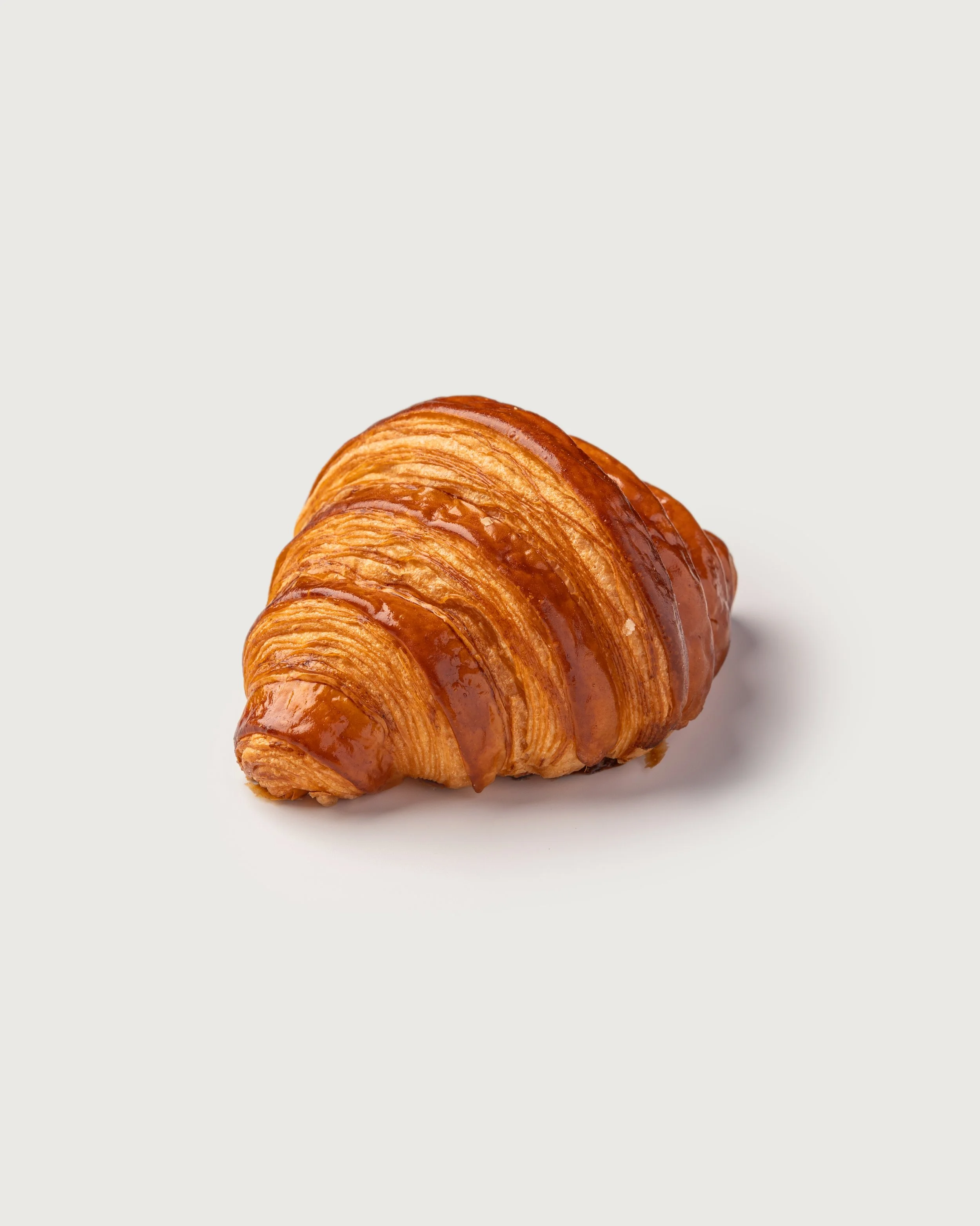 All-butter Croissant with glossy, golden lamination — Social Goods Modern Bakery.