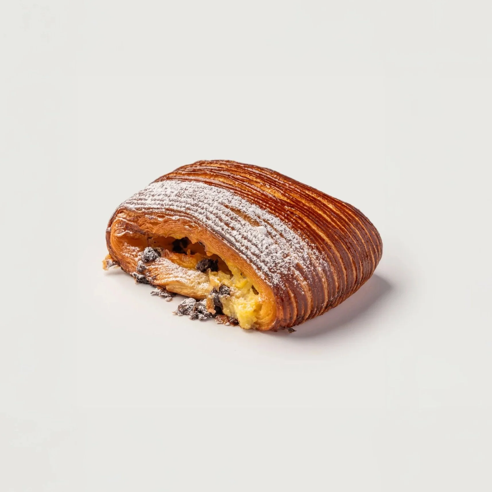 Pain Suisse — flaky laminated dough filled with custard and chocolate chips, dusted with powdered sugar.