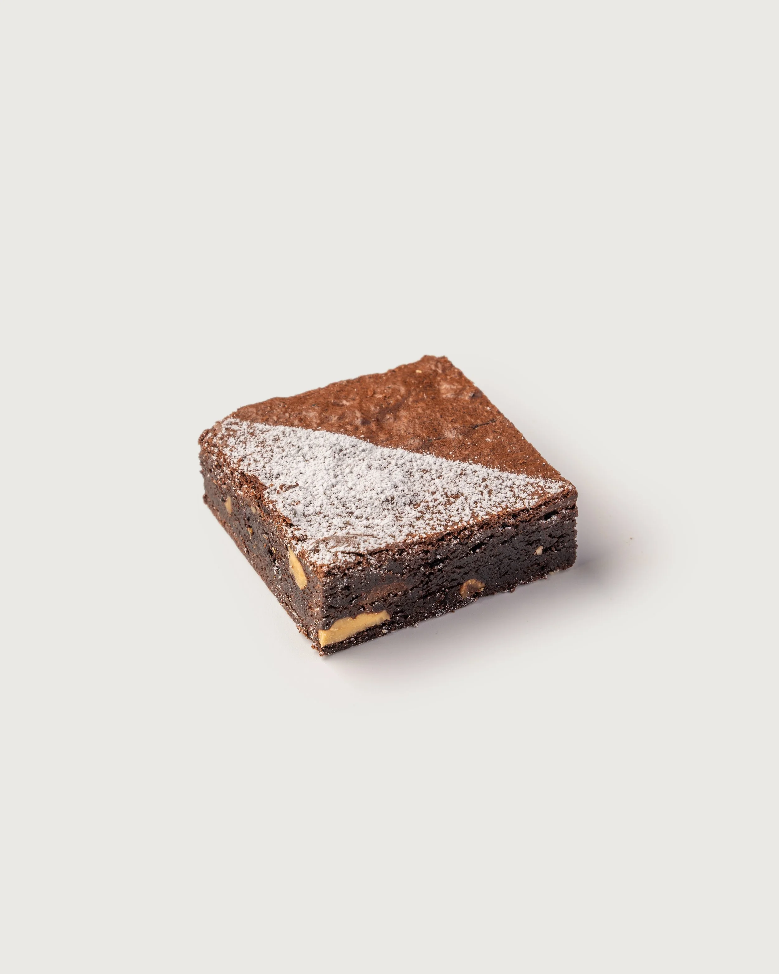 Brownie with Walnuts — dense chocolate brownie dusted with powdered sugar, Social Goods Modern Bakery.