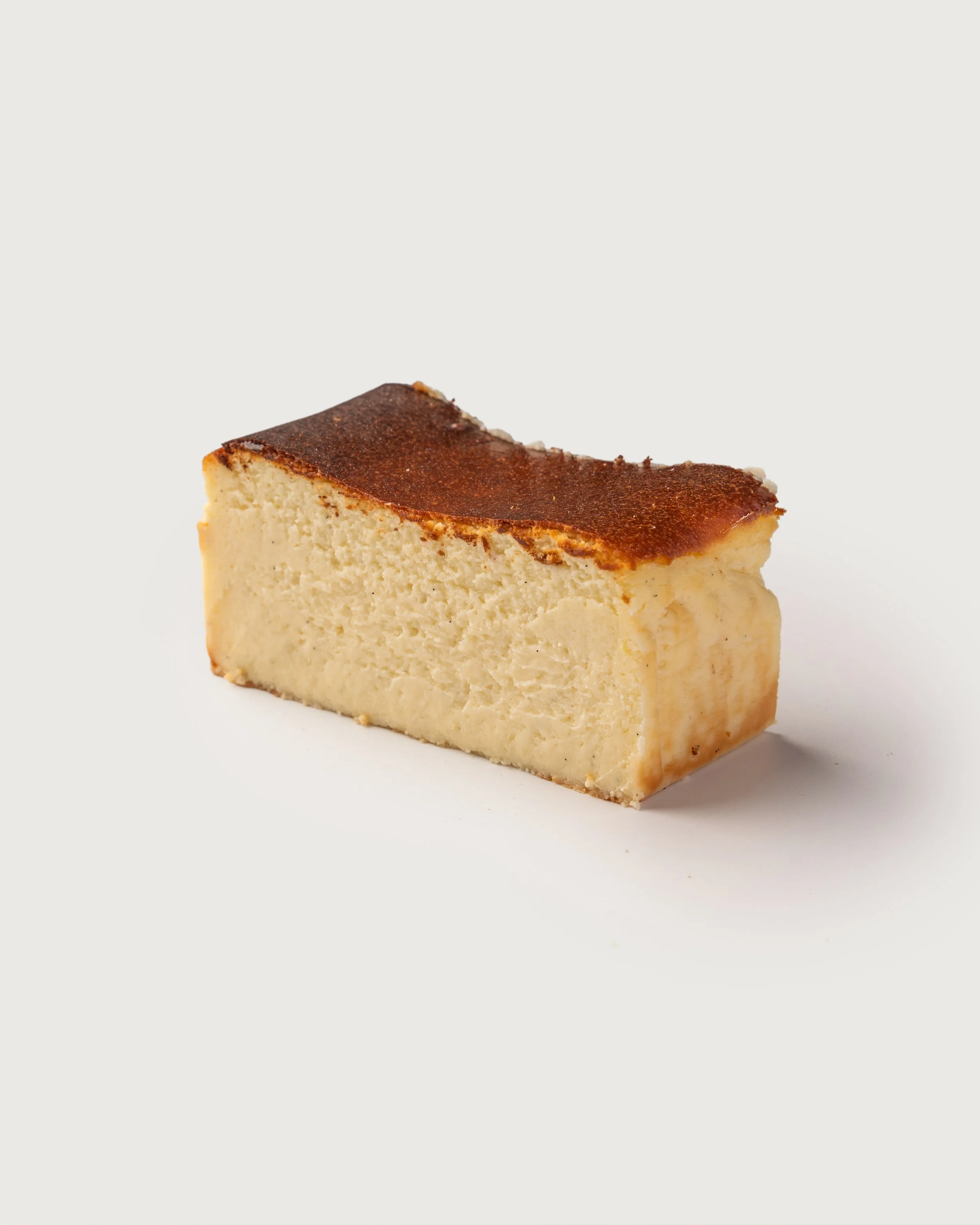 Basque Cheesecake — burnt-top slice with creamy interior, Social Goods Modern Bakery.