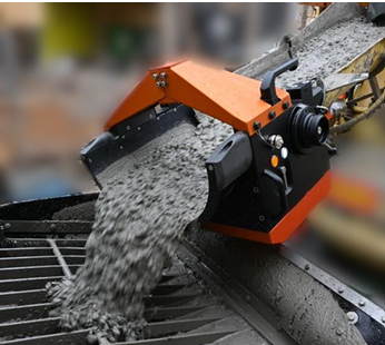 Industrial conveyor machine pouring gravel or small rocks.
