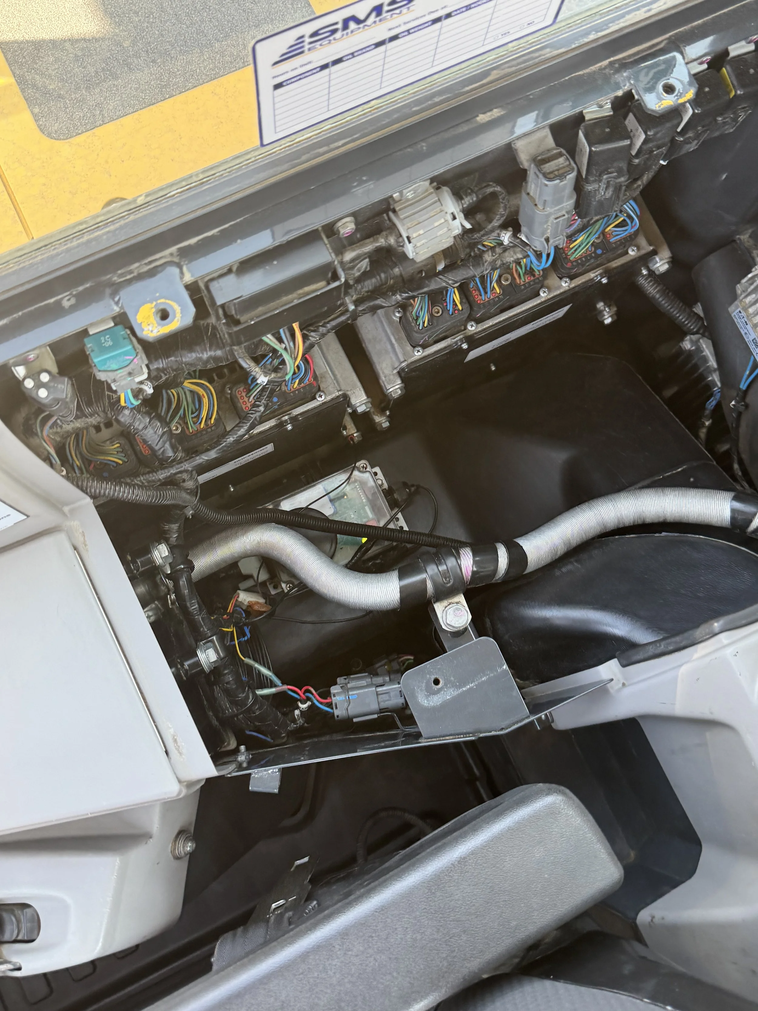 Close-up of an electronic control panel with wiring and components visible, likely inside a piece of machinery or vehicle.