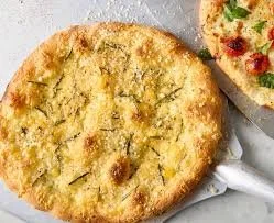 Close-up of a cooked pizza on a baking sheet, showing a golden crust and some toppings.