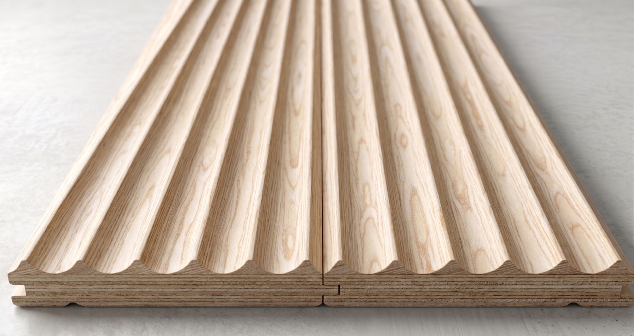 Due pezzi di legno di pino con una superficie a forma di onda e scanalature, appoggiati su una superficie bianca.