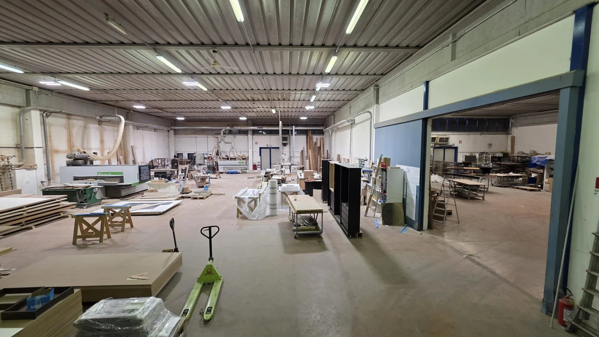 Interno di una falegnameria con diverse attrezzature e materiali per la lavorazione del legno.