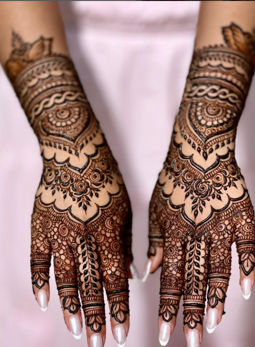 Close-up of two hands with intricate henna (mehndi) designs on palms, fingers, and wrists, with a blurred light background. A highlight of the Culture Pool fest by Utopia Experiences to showcase coastal culture through art