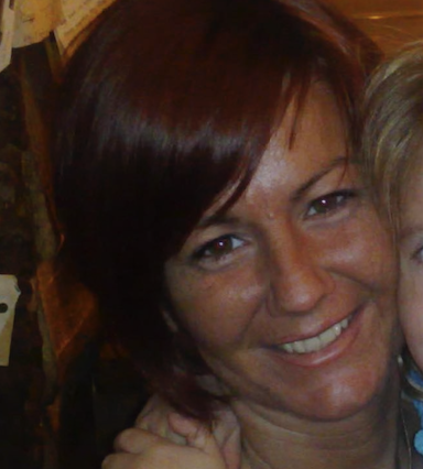 Close-up of a smiling woman with dark brown hair.