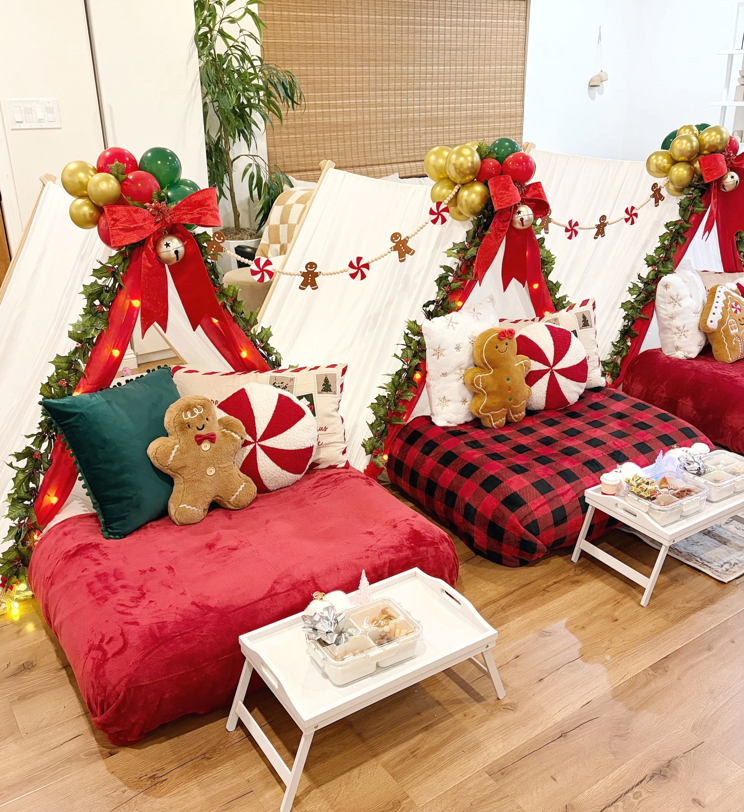 Christmas-themed display with a pillow, a gingerbread plush, a red and white peppermint plush, and holiday decorations including balloons for a Christmas-themed kid's sleepover party.