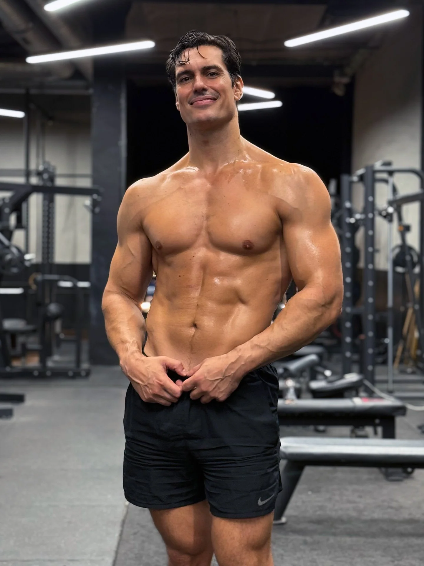 Fran Melero en el gimnasio, sonriendo y posando frente a pesas y equipos de entrenamiento.