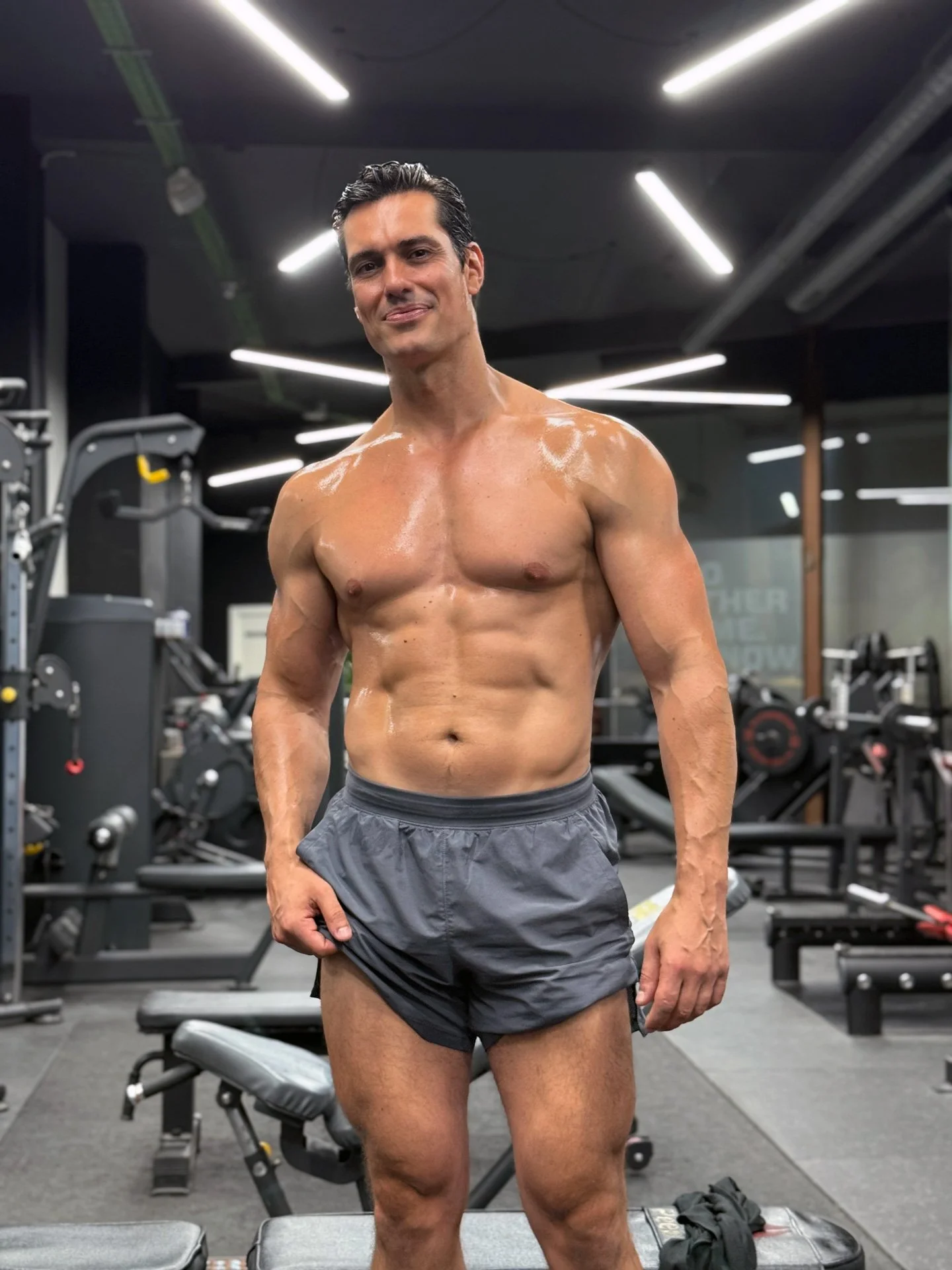 Fran Melero en el gimnasio, después de hacer ejercicio, con equipo de entrenamiento alrededor.