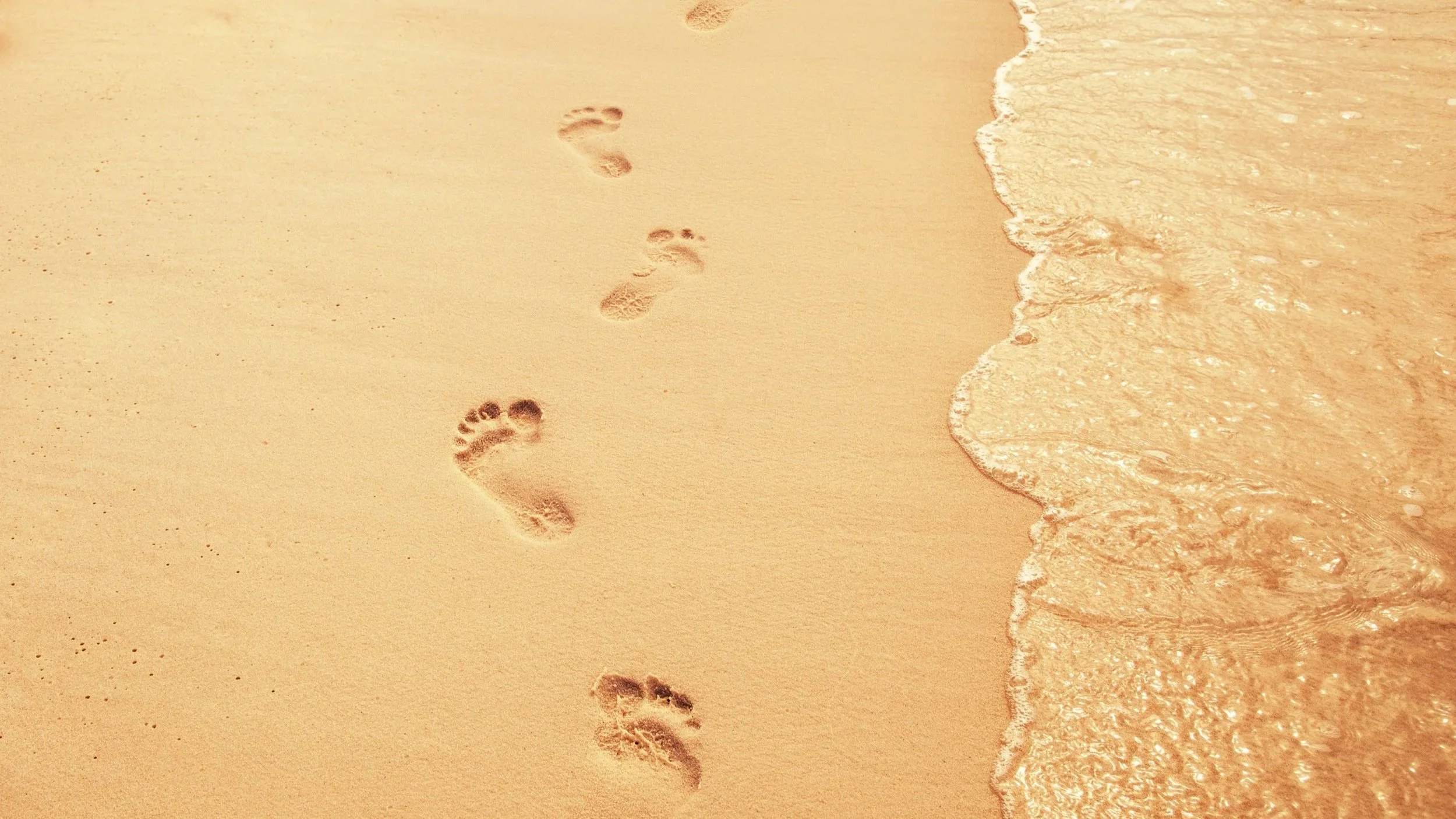 Spuren im Sand als Metapher für Loyalität, Gewohnheit und den Weg zur Veränderung.