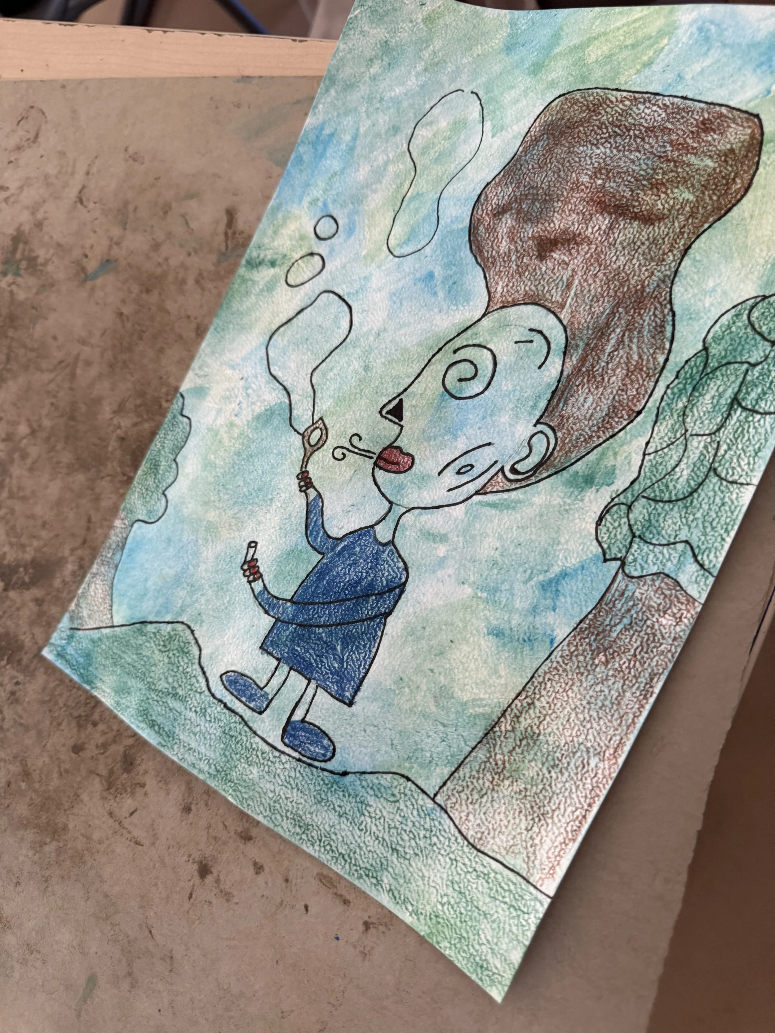 Kindtekening van een blauwe figuur die zeepbellen blaast, gemaakt tijdens een creatieve les bij Studio XXVIII.