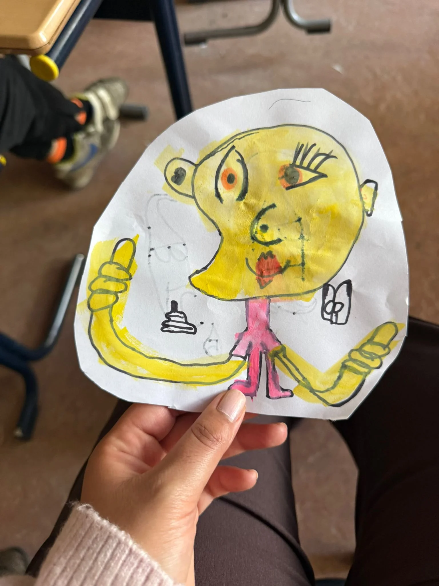 Kind toont een kleurrijke tekening van een vrouw, gemaakt tijdens een creatieve les bij Studio XXVIII.