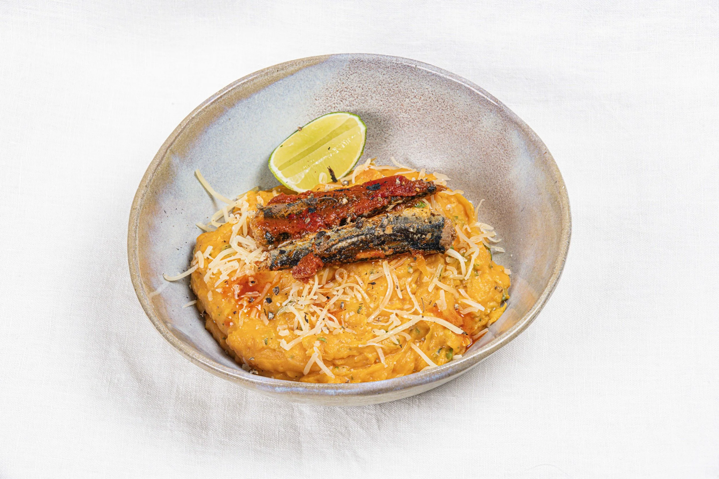 Riz garnie de poisson, fromage, tomate, accompagné d'une tranche de citron vert. Par le photographe culinaire Yves Daniel. 