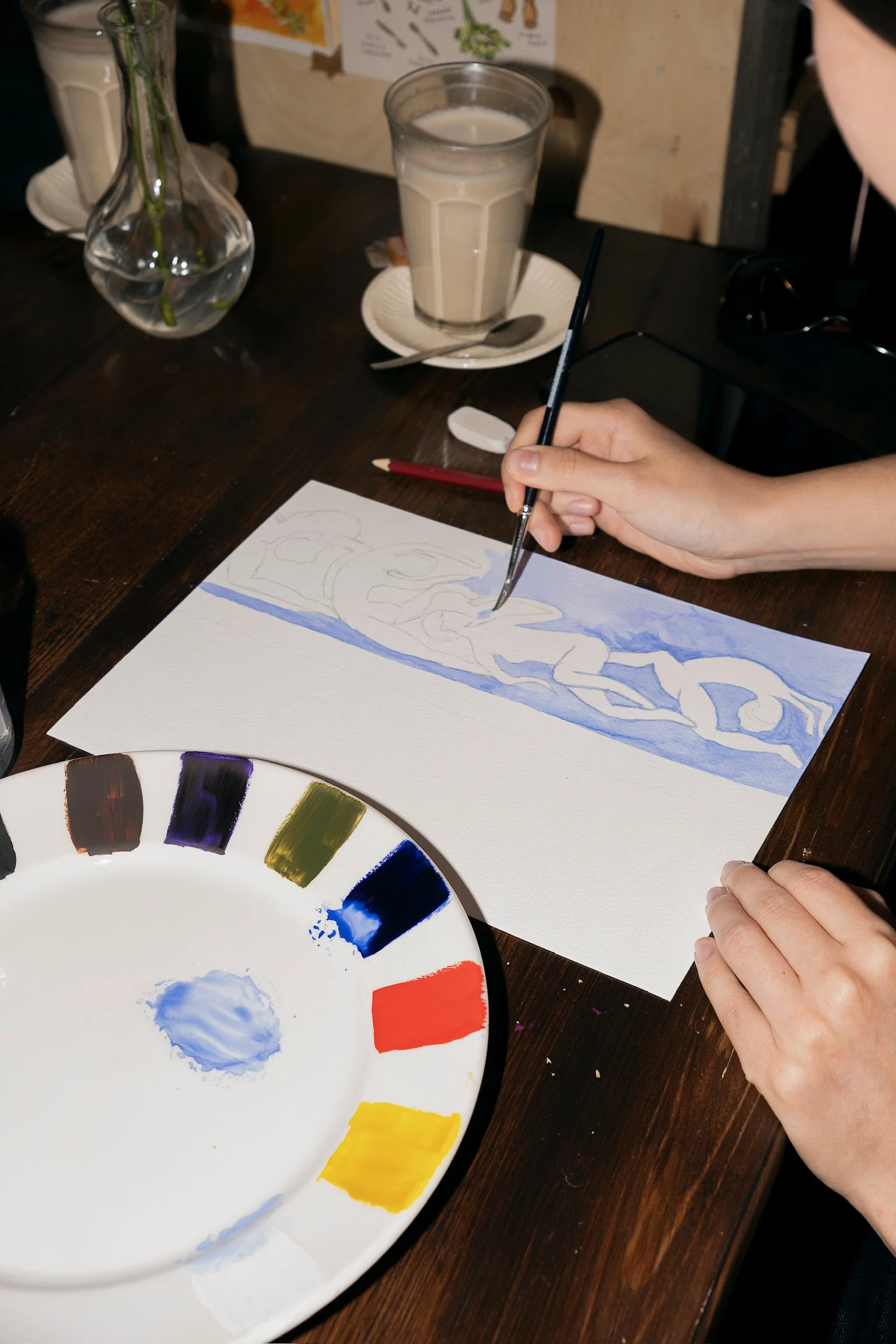 Person painting with watercolours during a creative group activity at The Art Café in Amsterdam.
