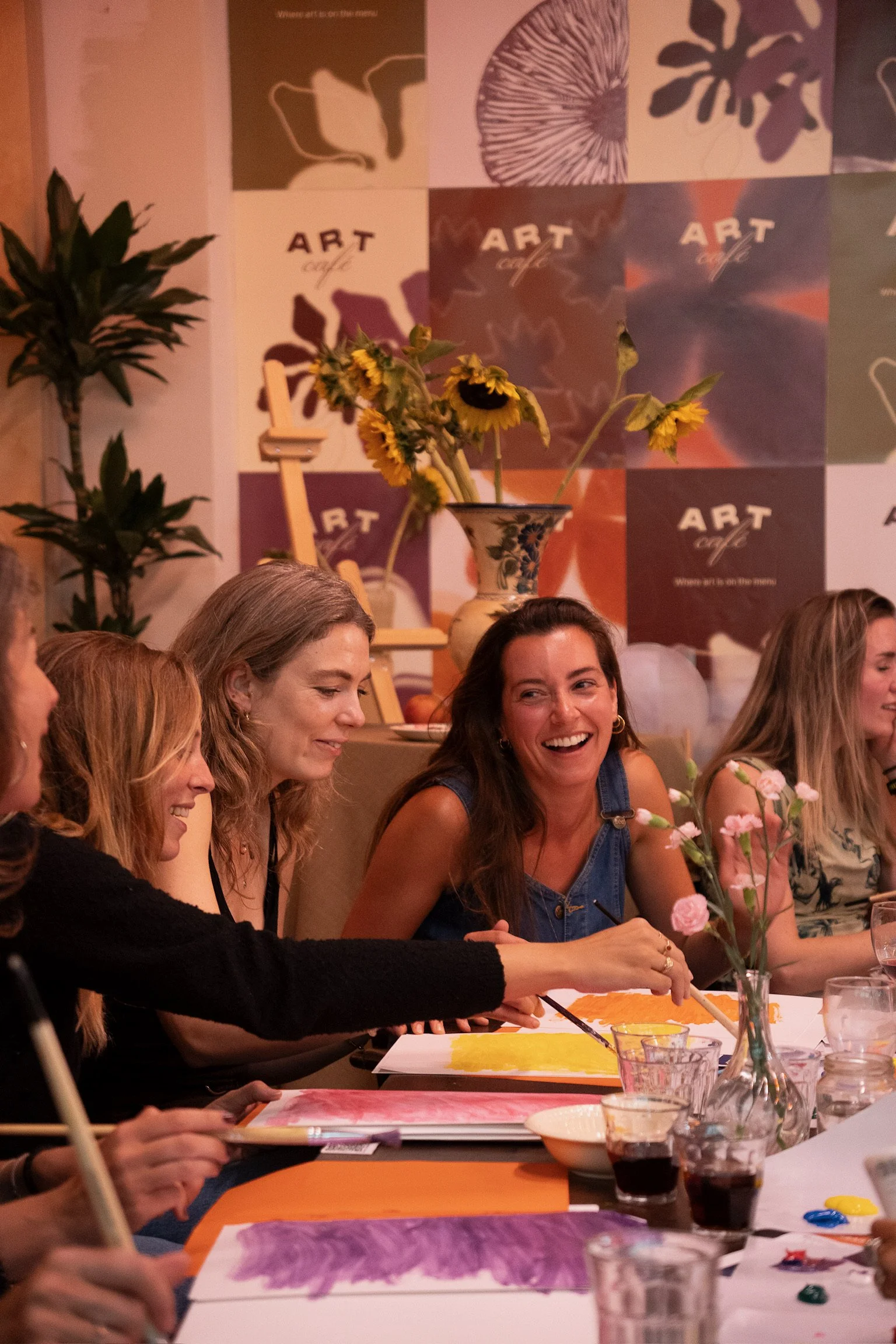 Friends celebrating together at The Art Café in Amsterdam, a cosy setting for a creative baby shower.