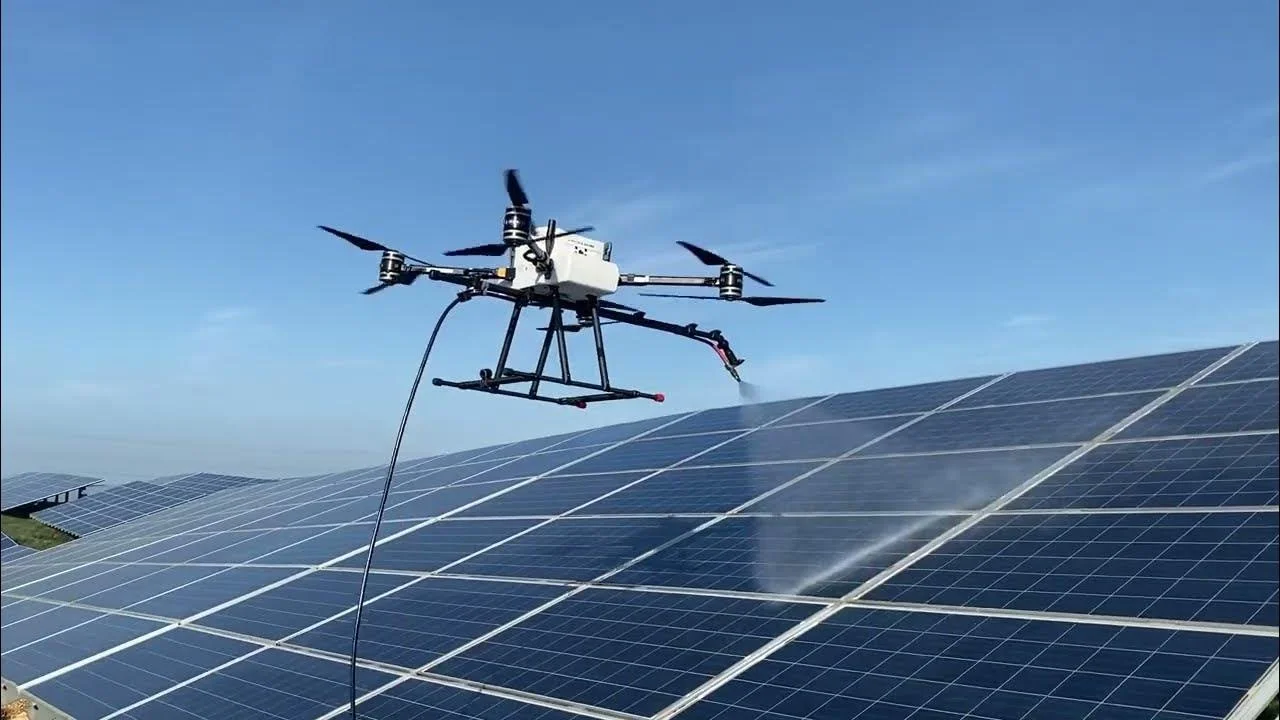 Un drone de pulvérisation vaporise des panneaux solaires lors de l'entretien d'une ferme solaire