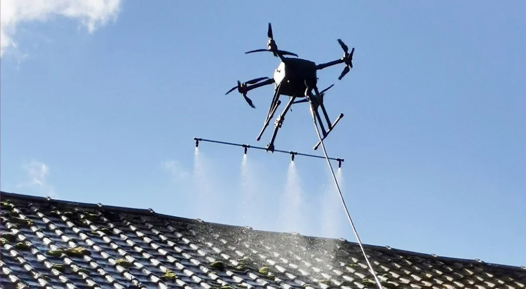 Un drone pulvérisant un traitement sur un toit pour le démousser en Aveyron