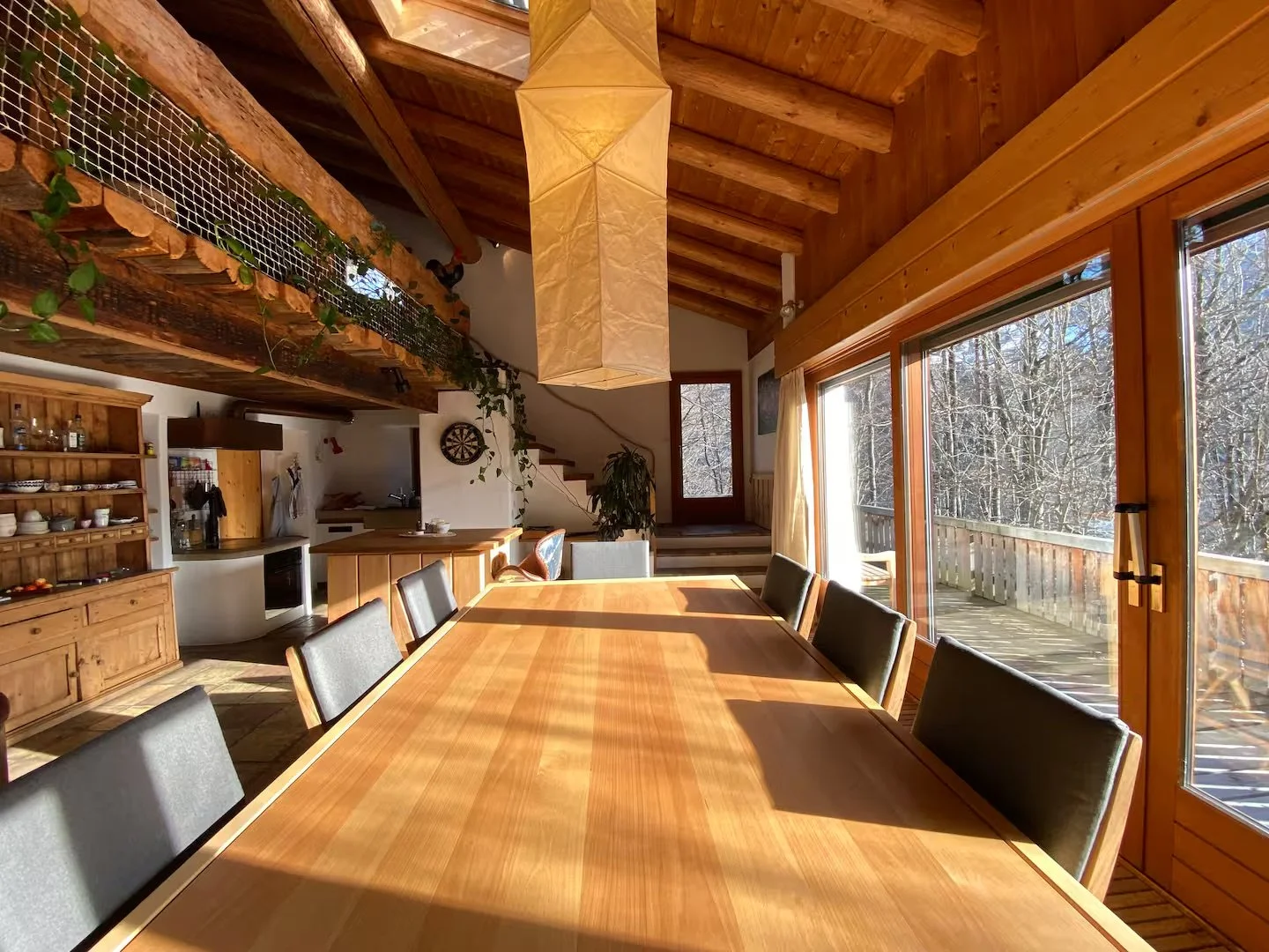 Bright Dining Room with Long Table: Black Chairs, Panoramic Snowy Views, Lantern – Exclusive Meals for WEF Networking & High-Level Discussions in Davos Chalet with Privacy. World Economic Forum, Davos, Switzerland.