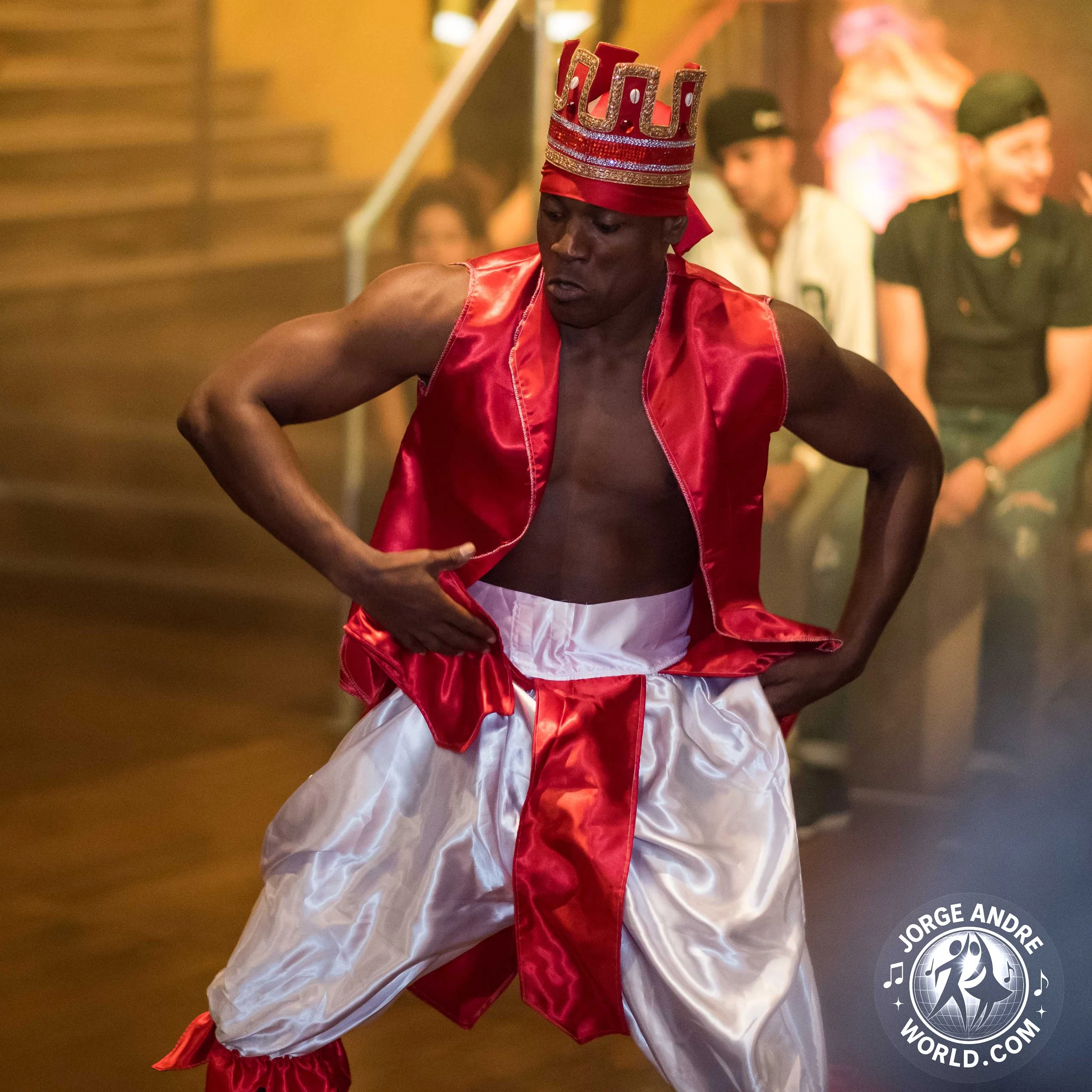 A man dressed as a traditional Mexican dancer in a red and white costume, performing a dance with a focused expression.