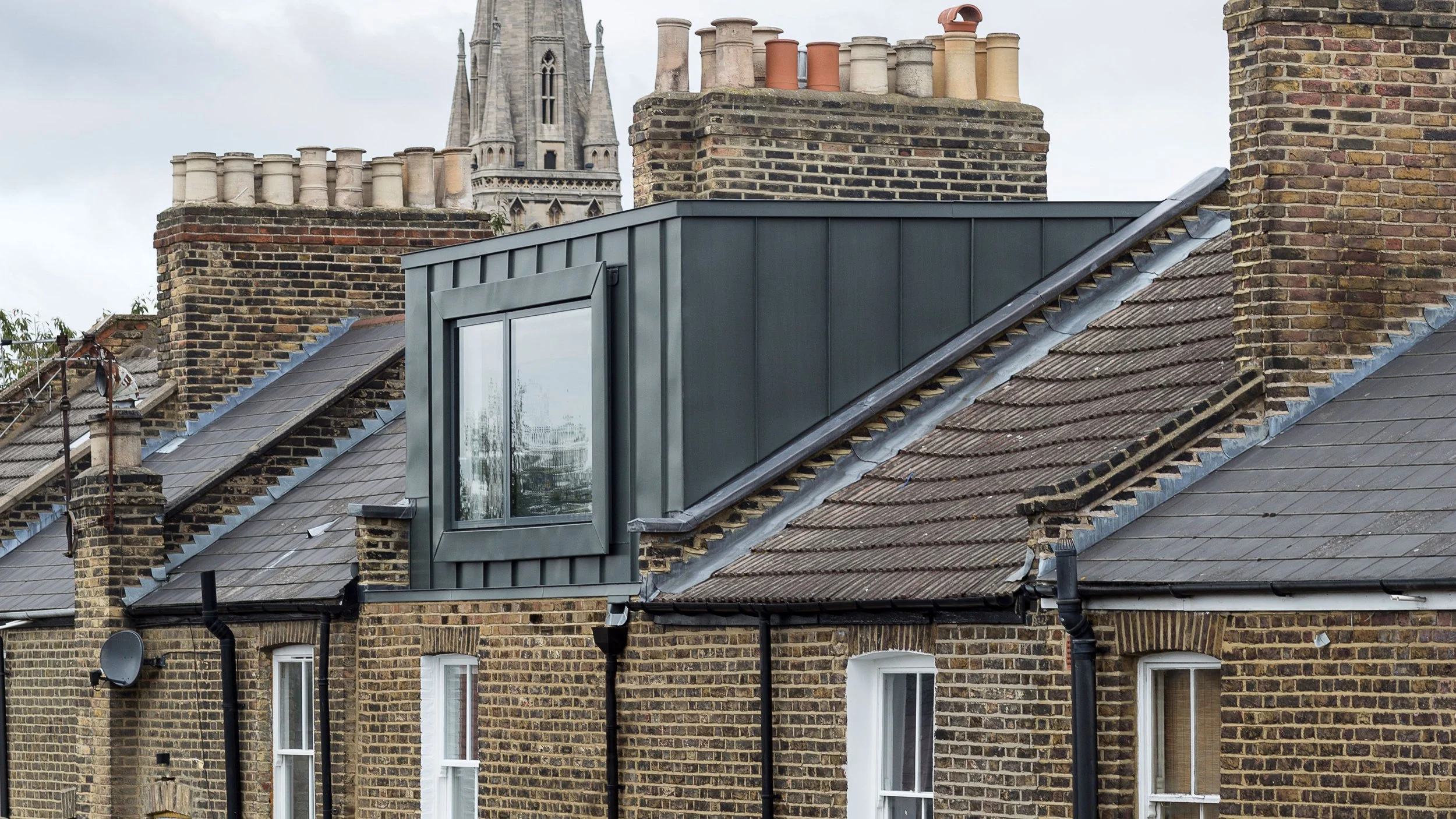 Modern zinc roof dormer on a Victorian house with church in background