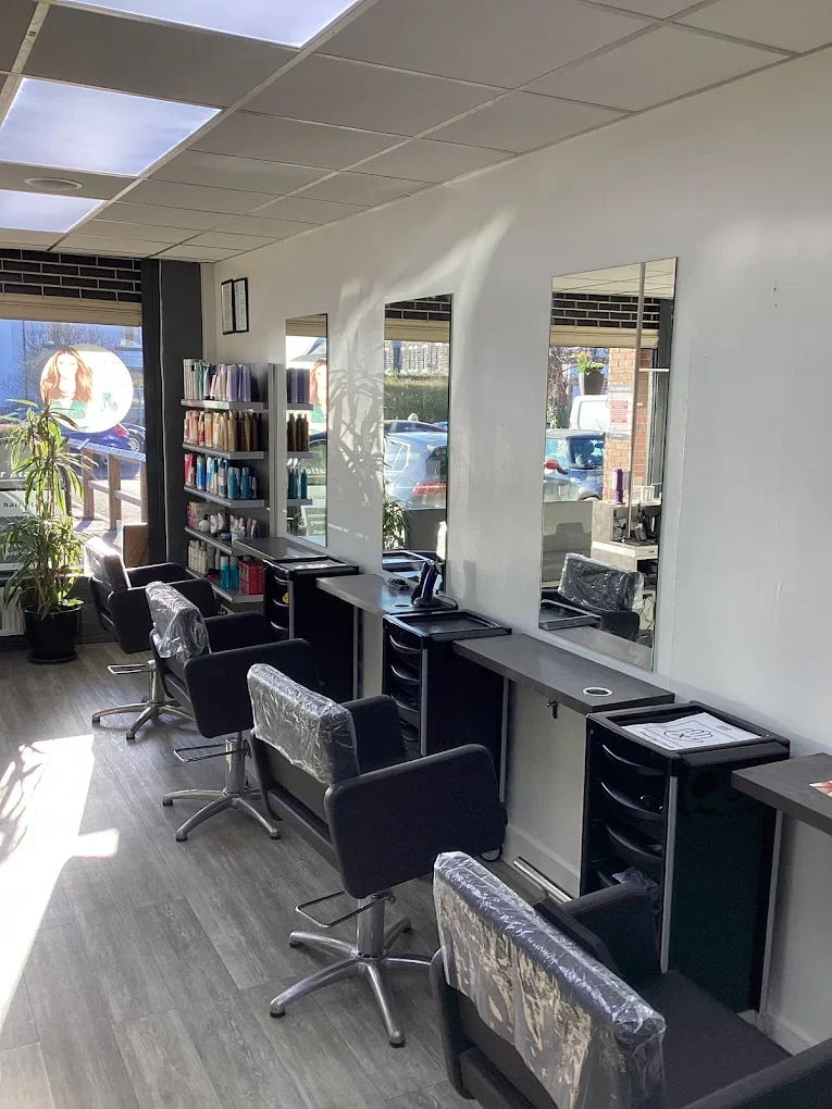Photo of hair salon including chairs, mirrors and hair products
