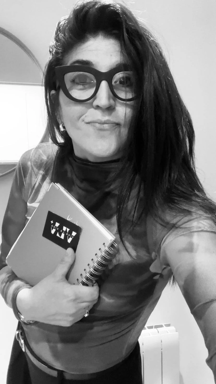 Romina Norry con gafas y libreta de Viva La Vida Events, en blanco y negro