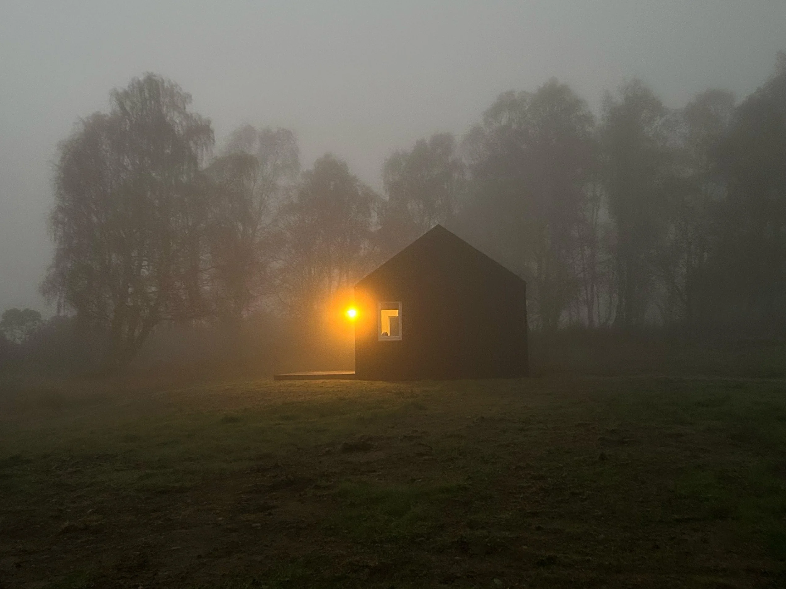 black tin cabin in fog Scottish Highlands