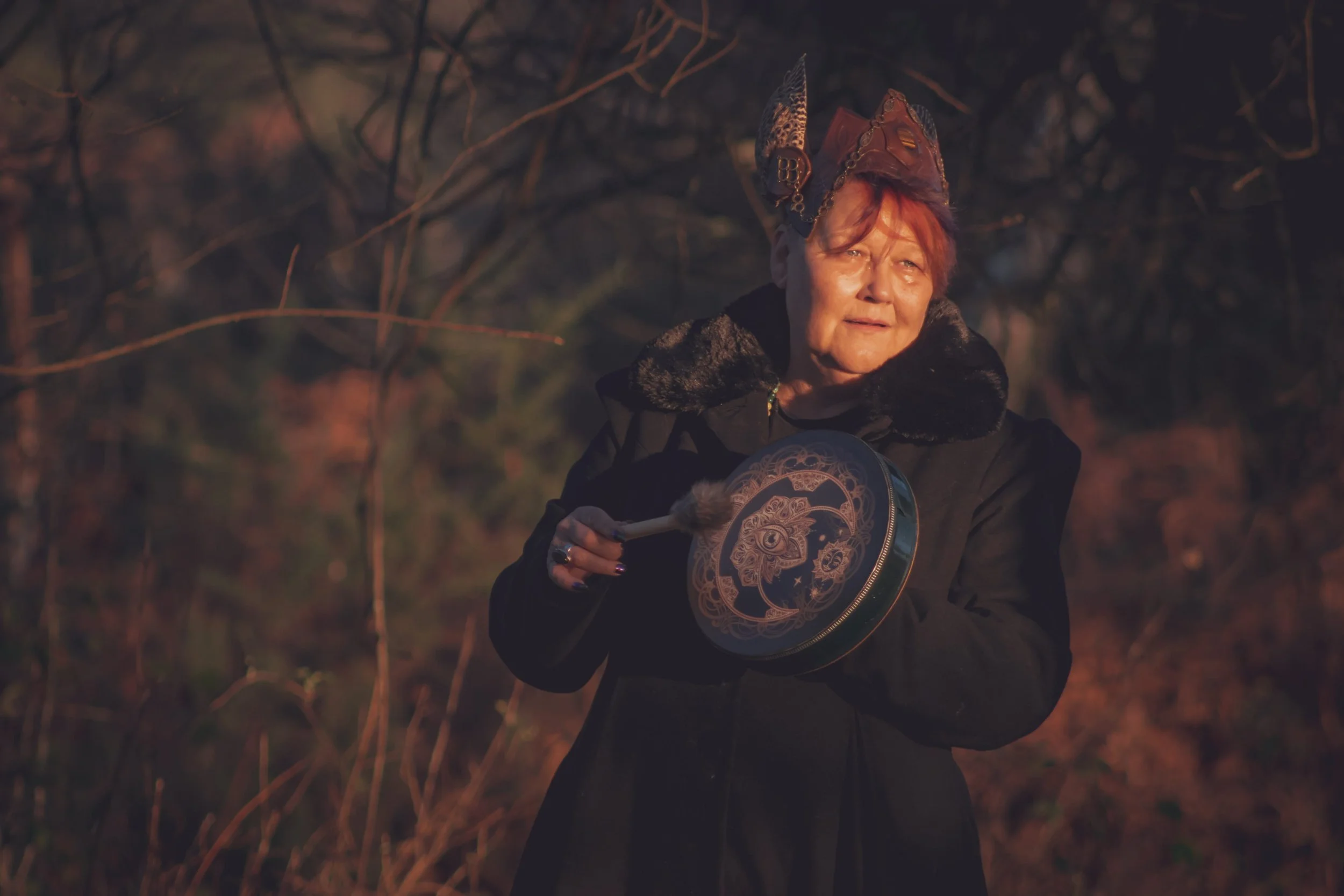 Priestess of Avalon 'SAXON SU' holding ceremonial drum in New Forest woodland Hampshire