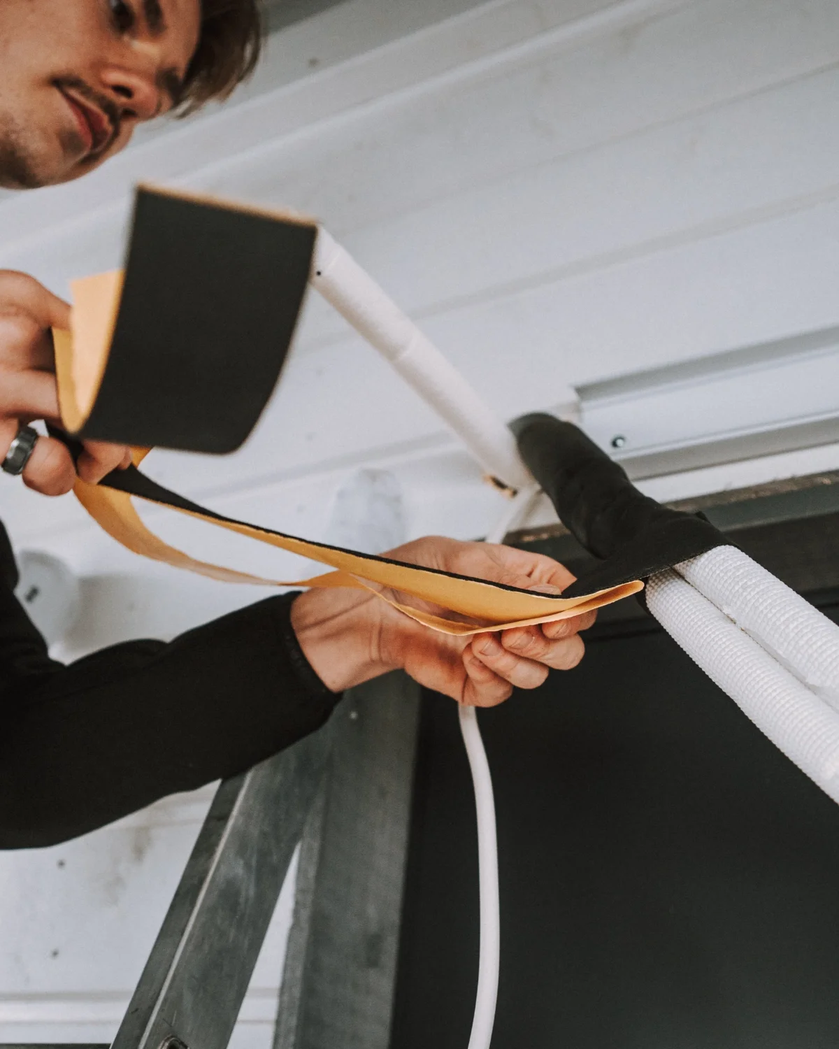 Henkilö työskentelemässä sähköasennuksen parissa.