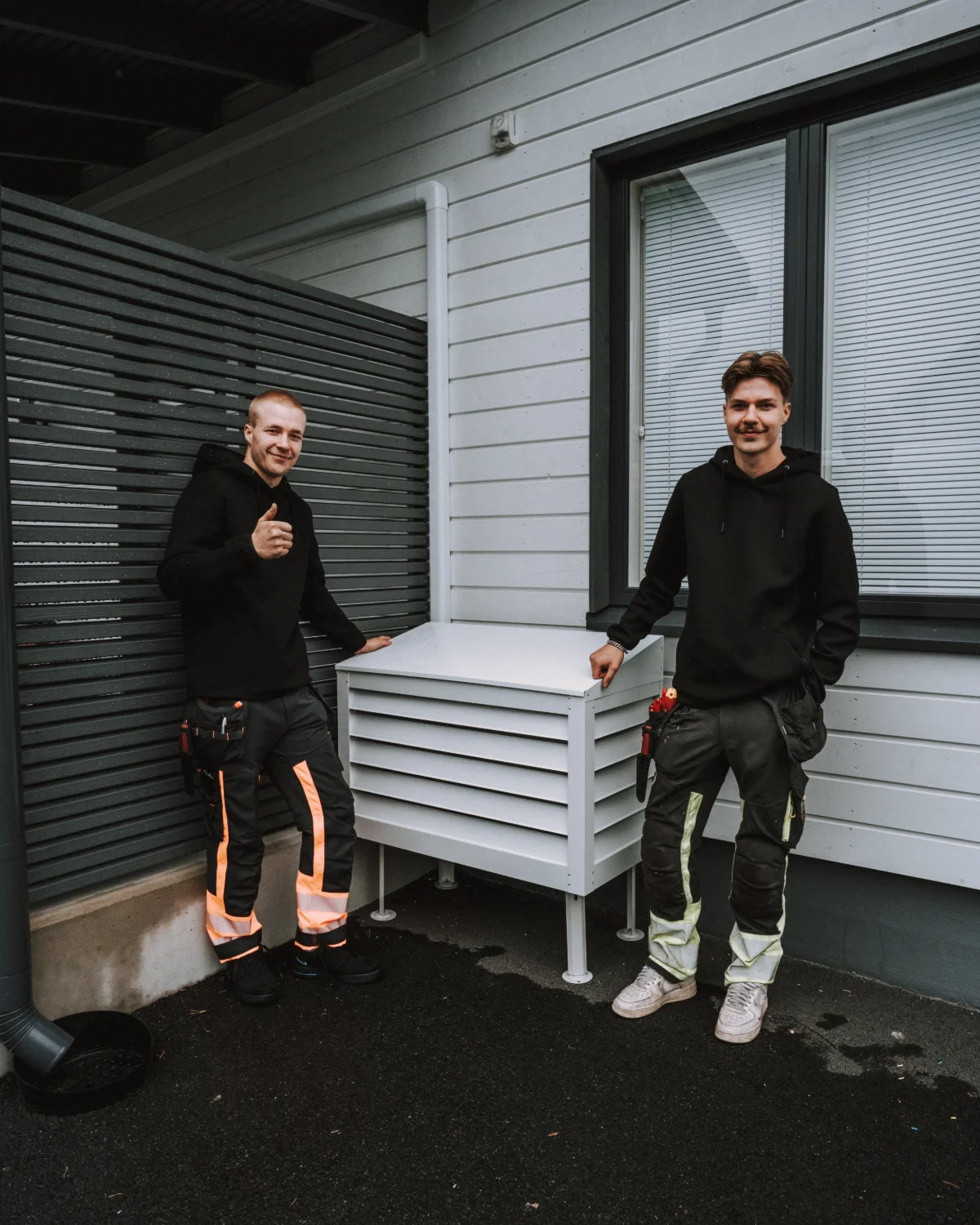 Tosikylmän iloinen ja ammattitaitoinen asennus- ja huoltoporukka työvaatteissa