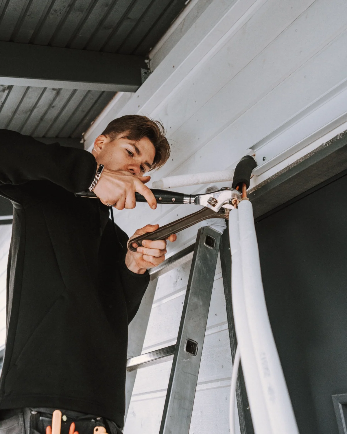 Mies asentaa tai korjaa sähköjohtoja seinään käyttäen betoniterästä.