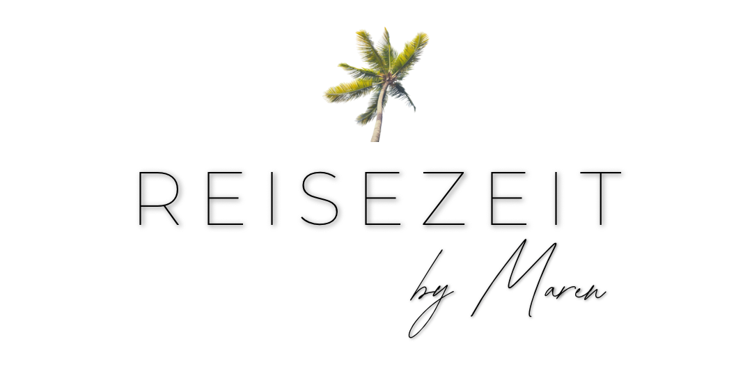 Eine Palme auf einer kleinen Sandinsel im Meer mit mehreren kleinen Inseln im Hintergrund, bei Sonnenuntergang.