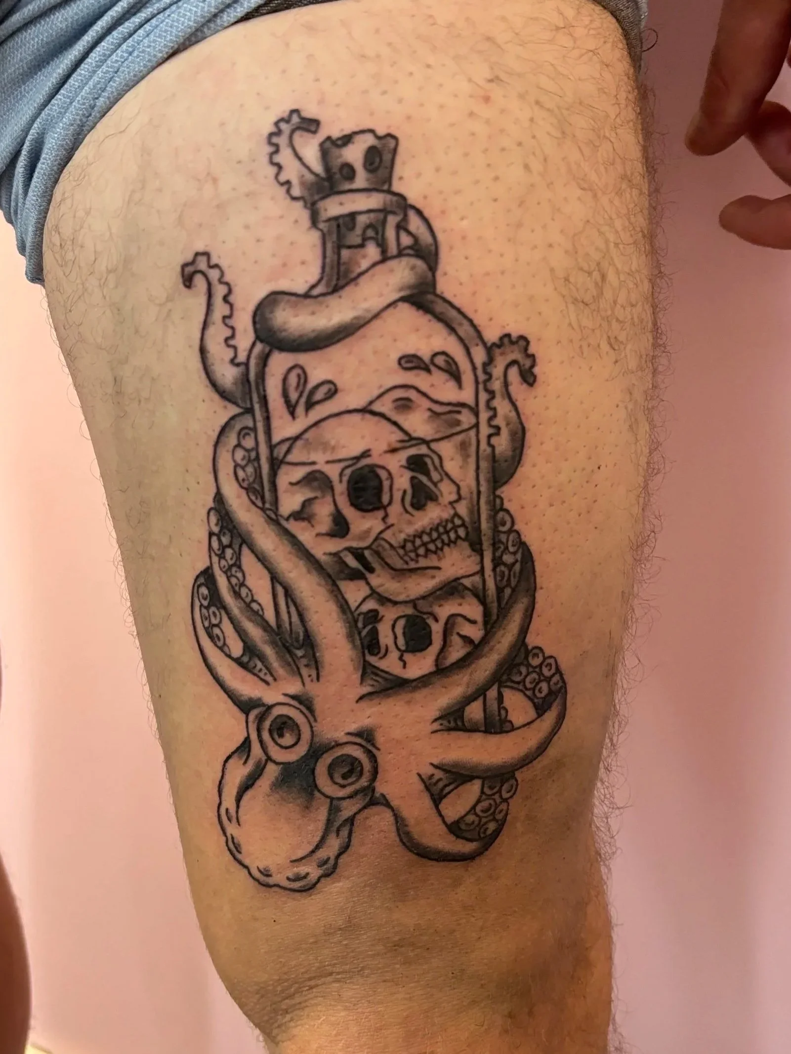 Tattoo of a jar with a snake, a skull, and an octopus inside.