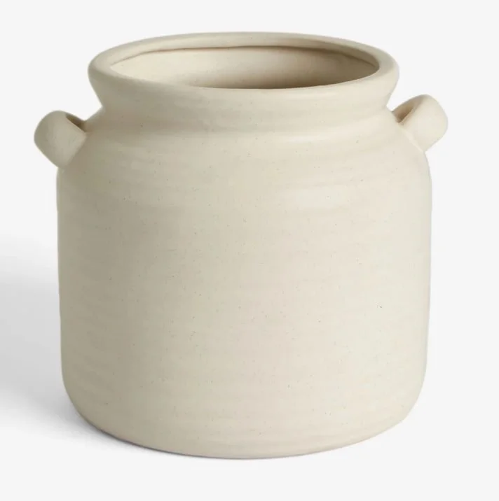 Empty white ceramic jar with small side handles, smooth surface, and rounded top opening.