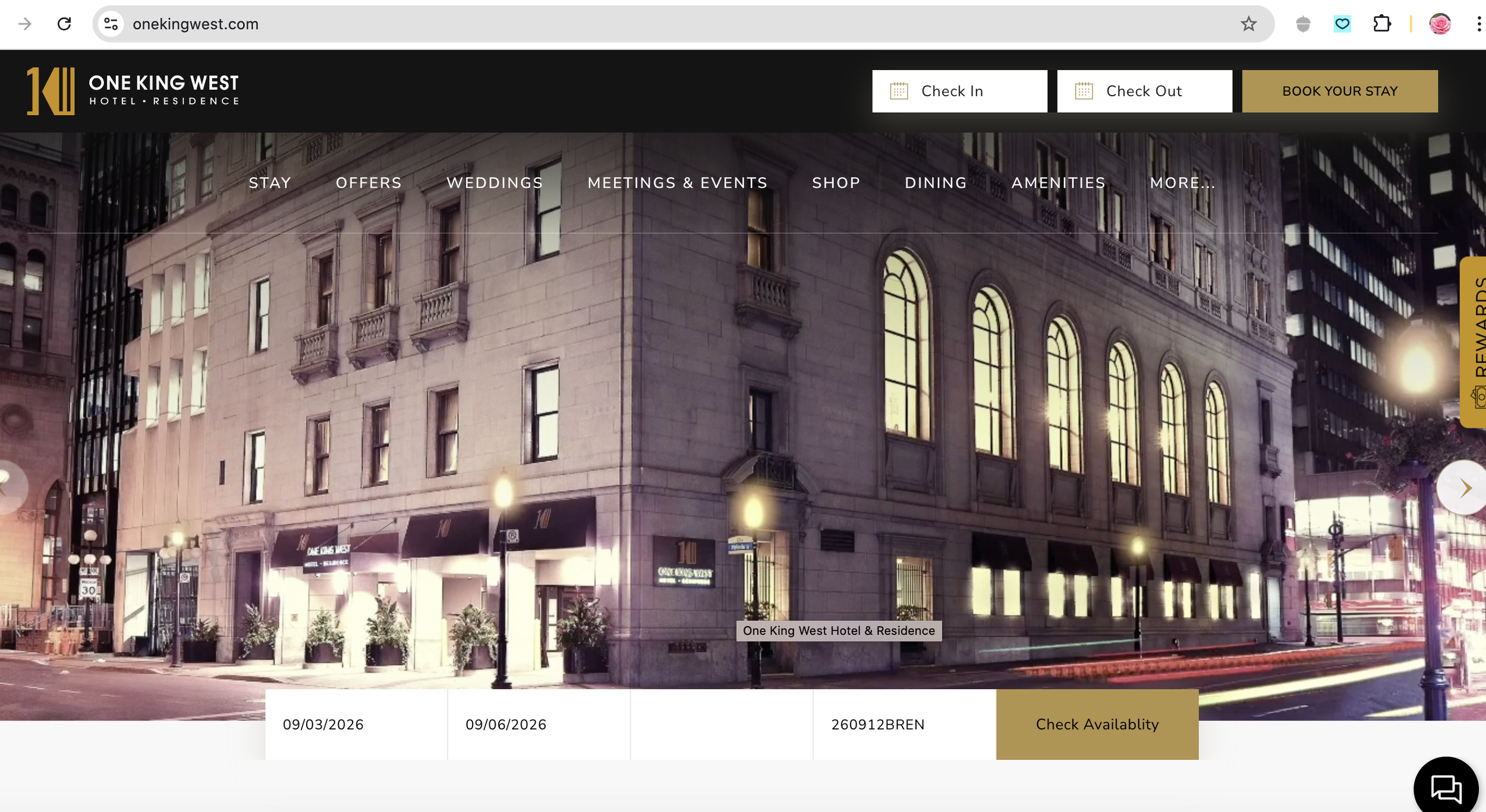 Nighttime exterior view of the One King West Hotel & Residence building with illuminated windows, street lamps, and signage.
