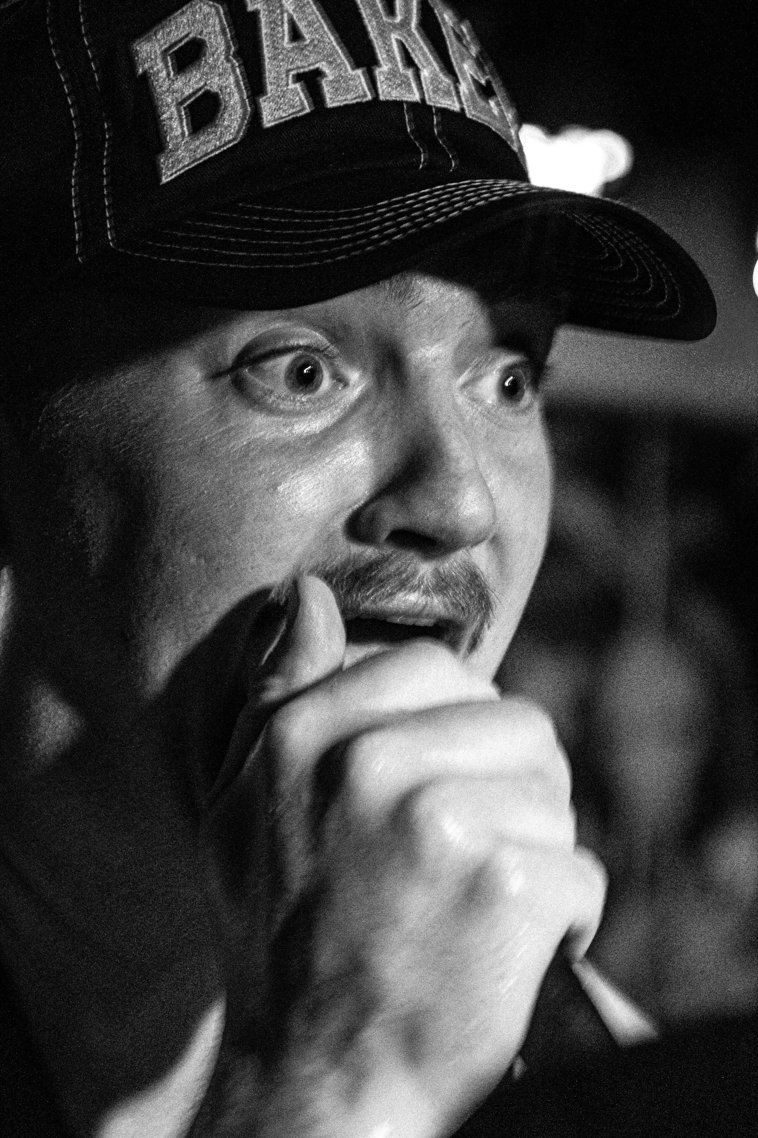 A close up black and white image of a singer of a hardcore band shouting intensely into the mic, taken at the music venue Boom in Leeds.