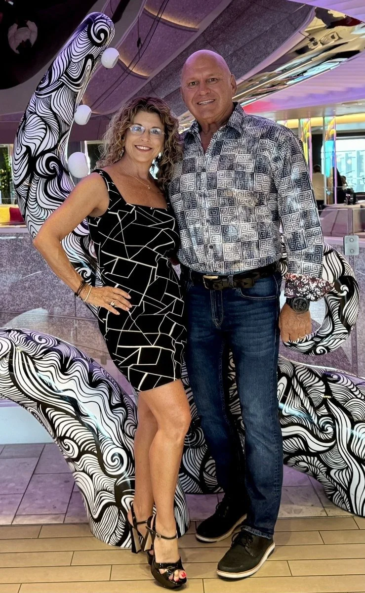 Jim and Mary Mincy of Aurévia Voyages aboard Virgin Voyages Resilient Lady in front of a black-and-white tentacle sculpture