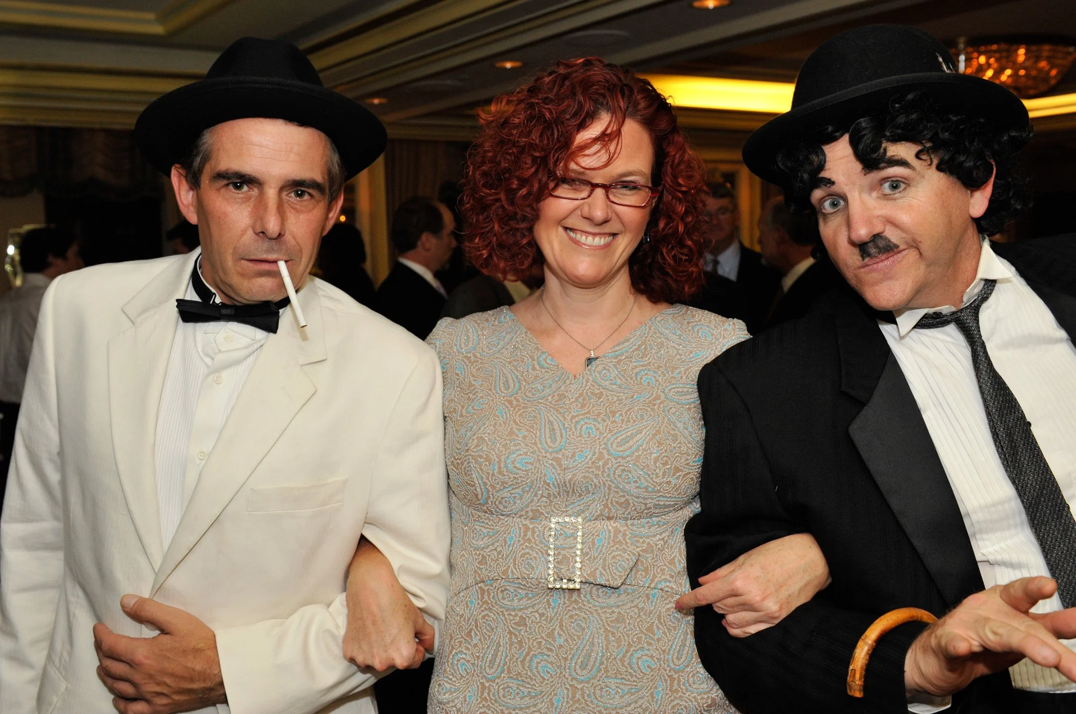 Guests posing with performers at an event.