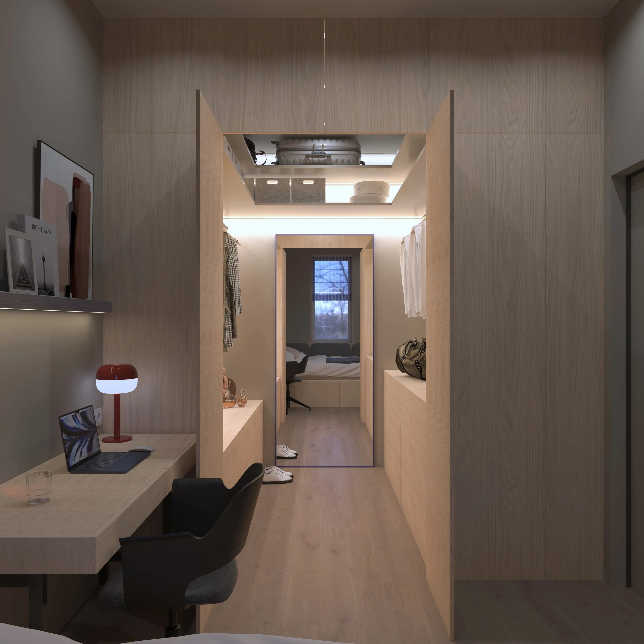 Interior view of a modern, minimalist apartment with a workspace and a bedroom visible through a doorway, featuring light wood finishes, a desk with a laptop and a red desk lamp, and slippers on the floor.