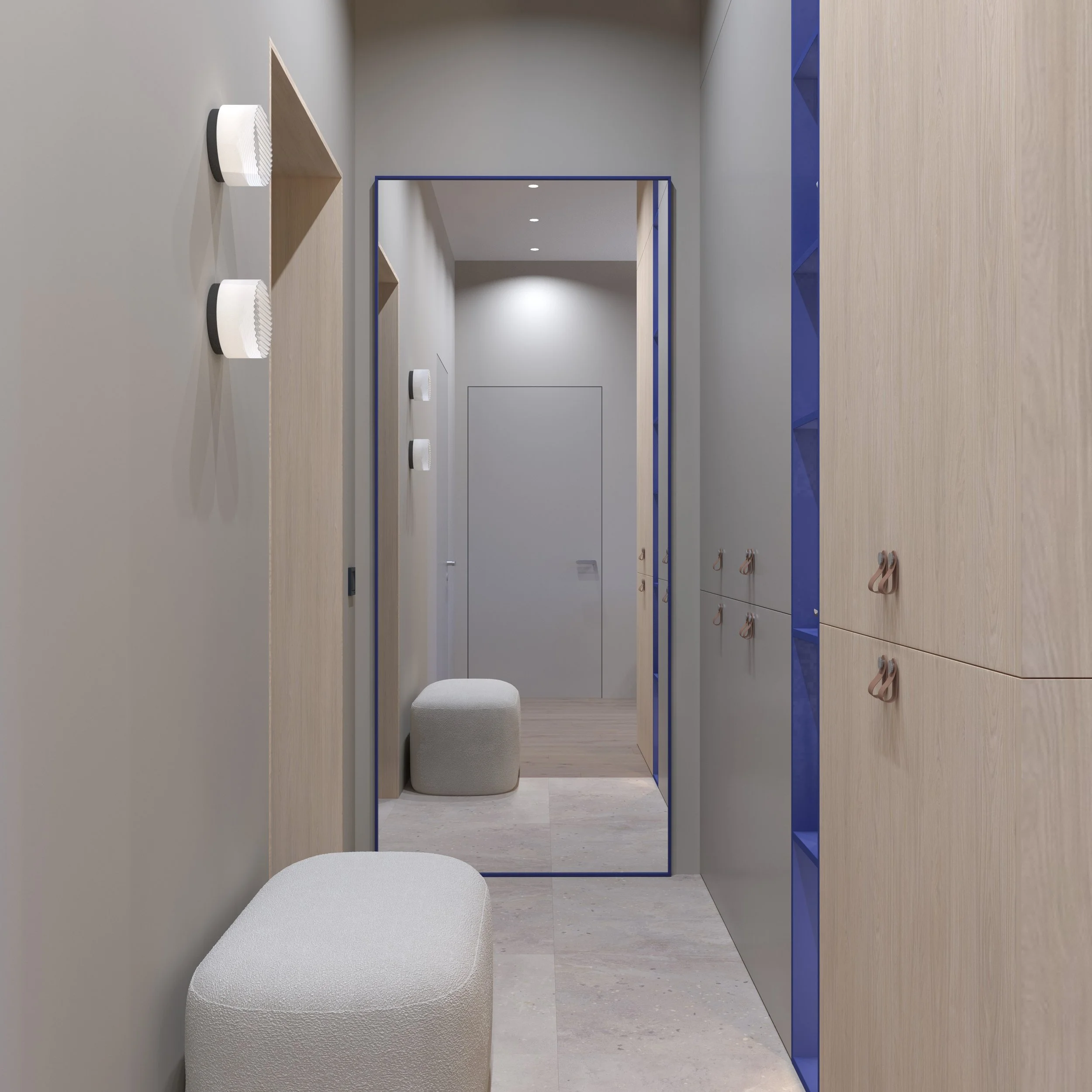 Modern hallway with beige walls, light wooden cabinets, and a large mirror reflecting a beige ottoman and doorway. The hallway features minimalist decor with wall-mounted lights.