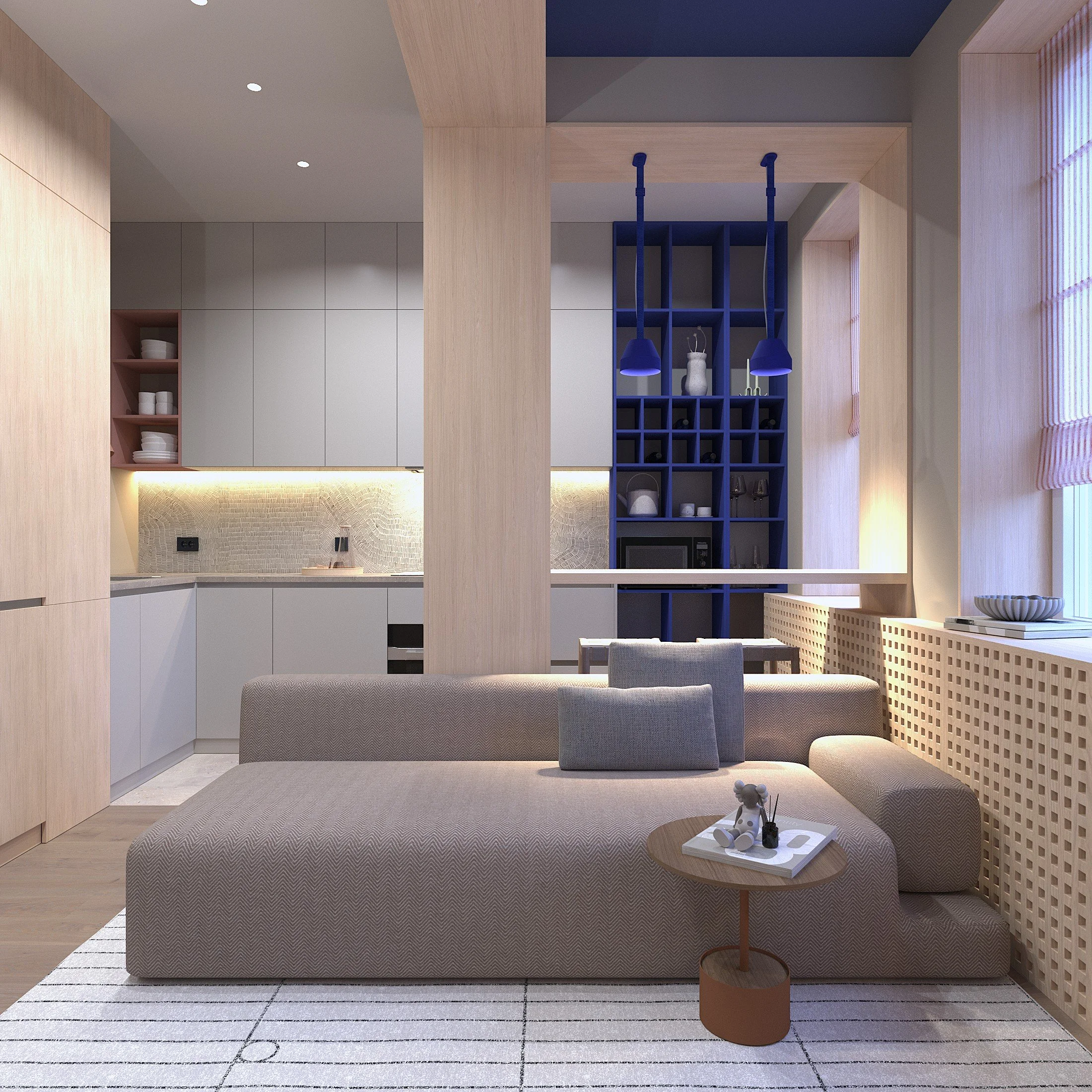 Modern living room with a beige sectional sofa, a wooden side table with decorative items, and large windows with pink blinds. The background shows a kitchen area with light-colored cabinets and a blue shelving unit.