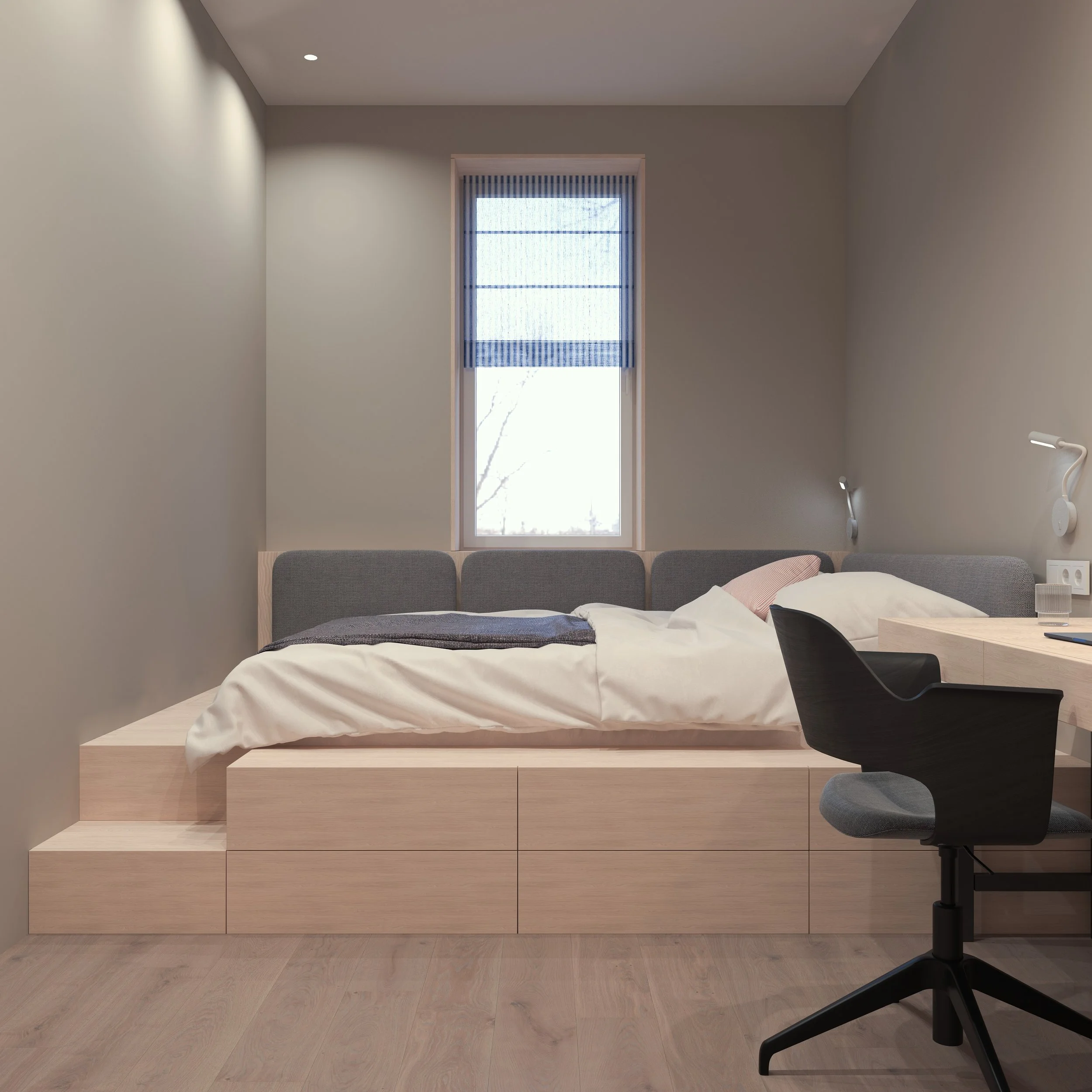 A modern bedroom with a bed on a raised wooden platform, a window with a blue striped shade, and a black office chair at a wooden desk. The bed has white bedding and pillows, with light-colored walls and wood flooring.