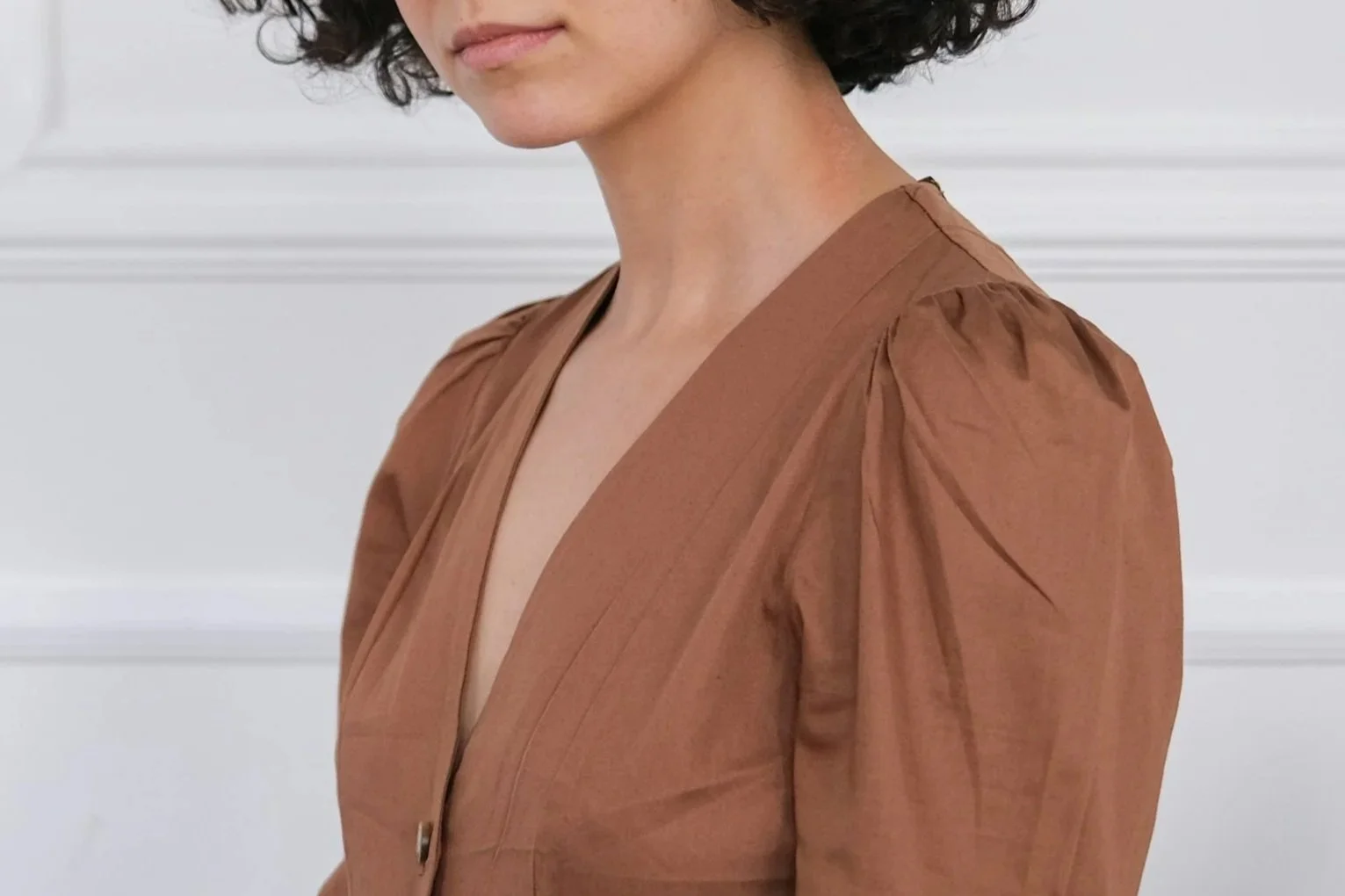 A woman in a copper, puff-sleeve dress