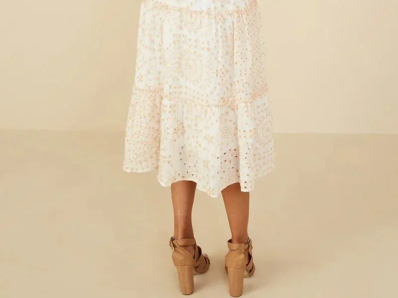 Woman in a white mid length dress that hits right in the middle of her calves