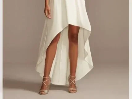 Woman in a white hi-low dress that it shorter in the front and longer in the back