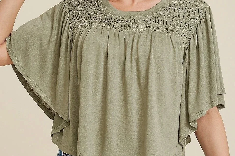 Woman in a green butterfly sleeve top