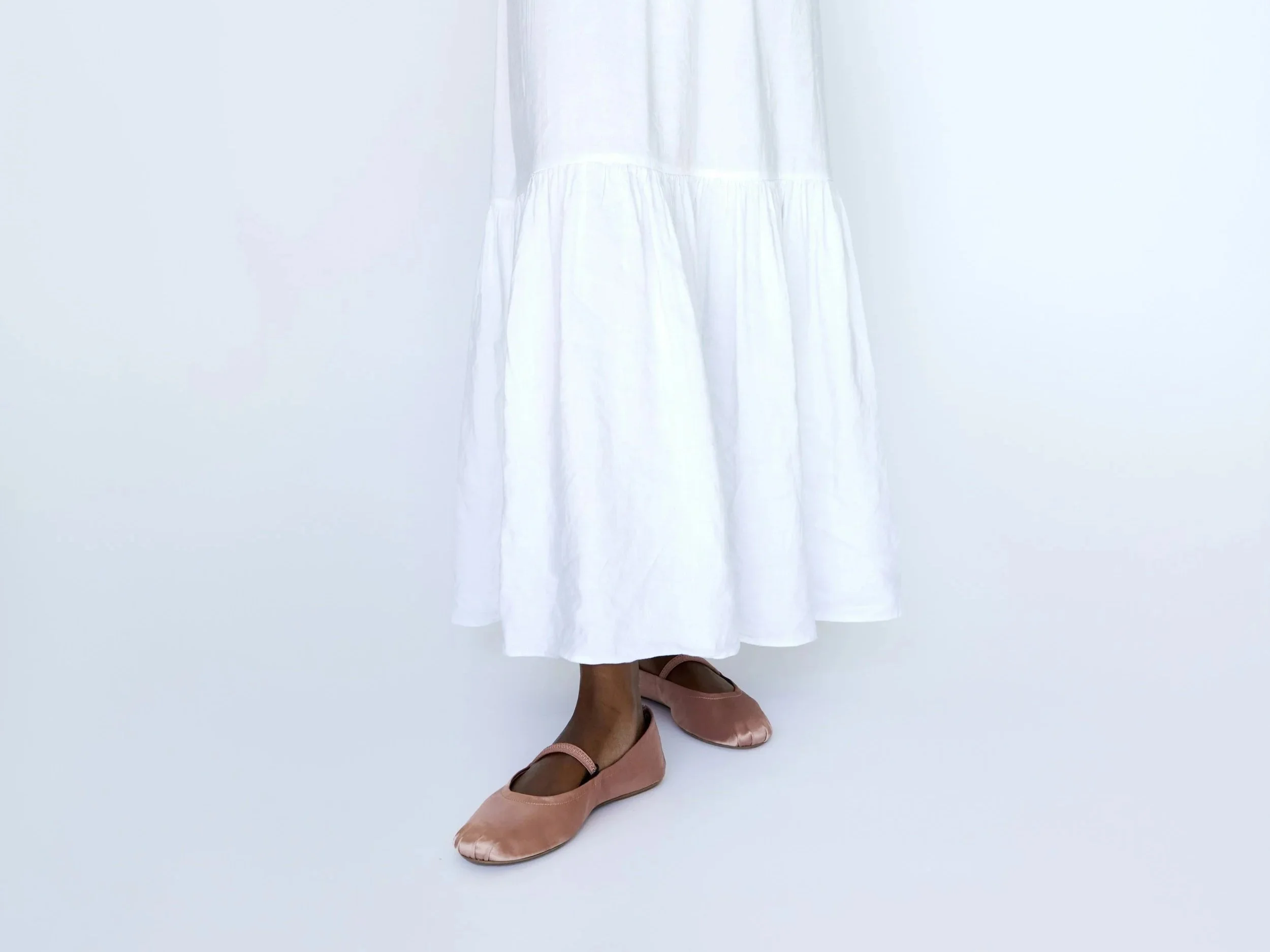 Woman in a white maxi length dress that hits just above her ankles