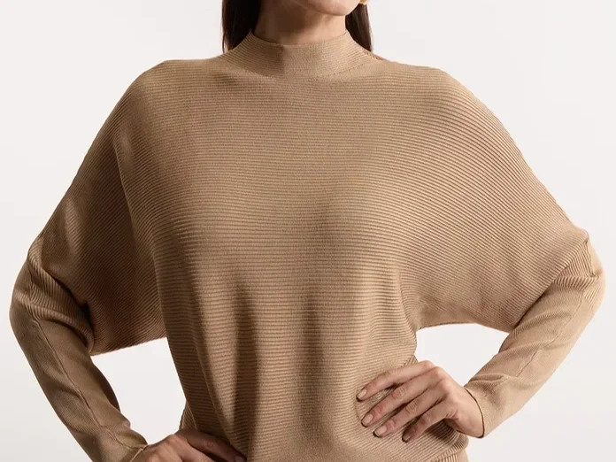 Woman in a tan dolman sleeve sweater