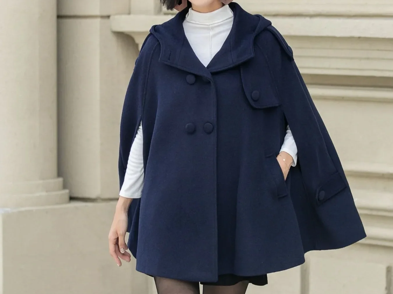 Woman walking in a navy cape jacket